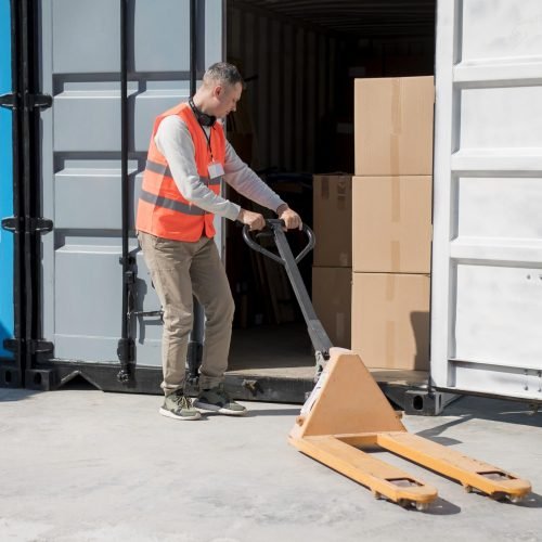full-shot-man-carrying-pallet-truck